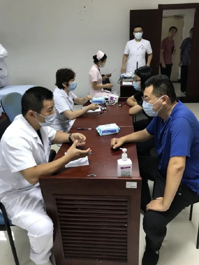 图为义诊现场医生为刑侦支队队员检诊问诊